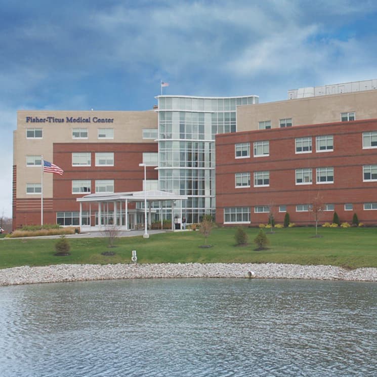view of a hospital building with a pond in front