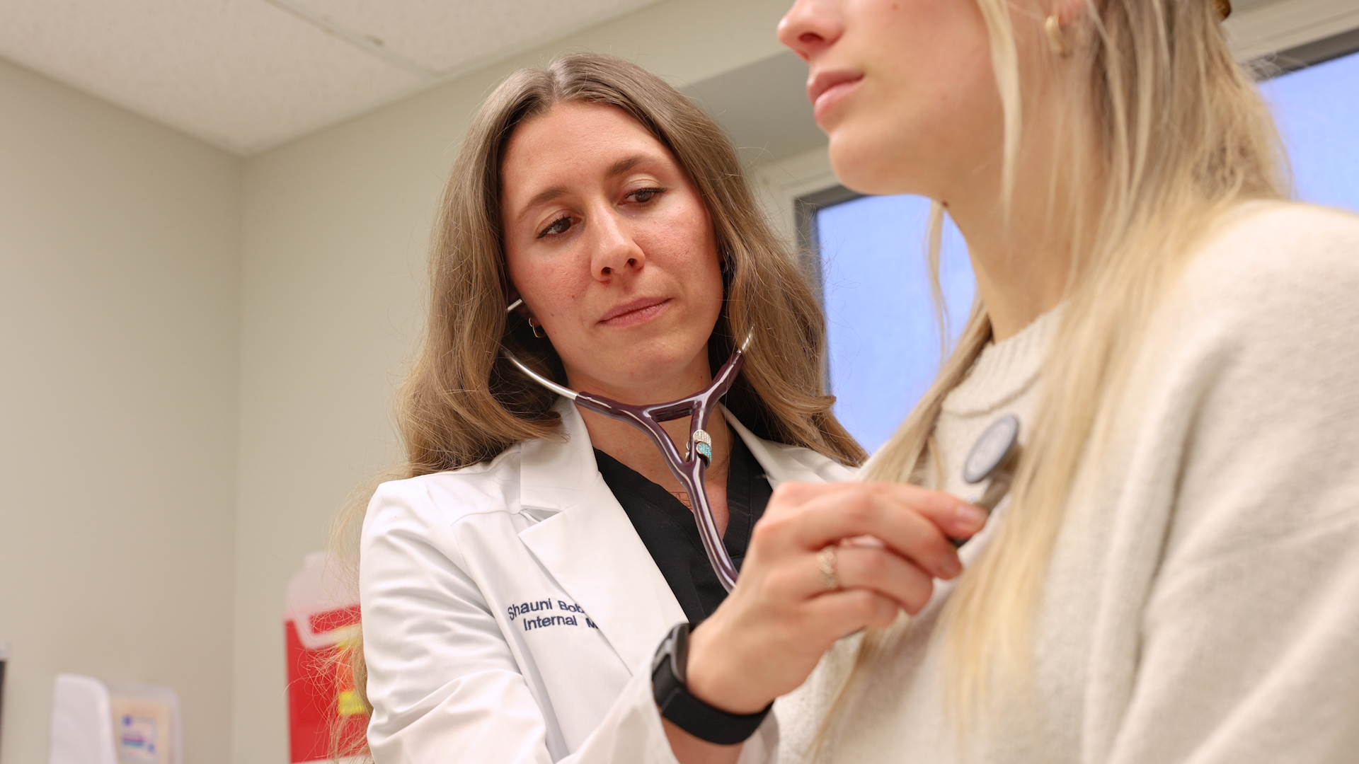 Dr. Shauni Bobbs using a stethoscope on a patient.