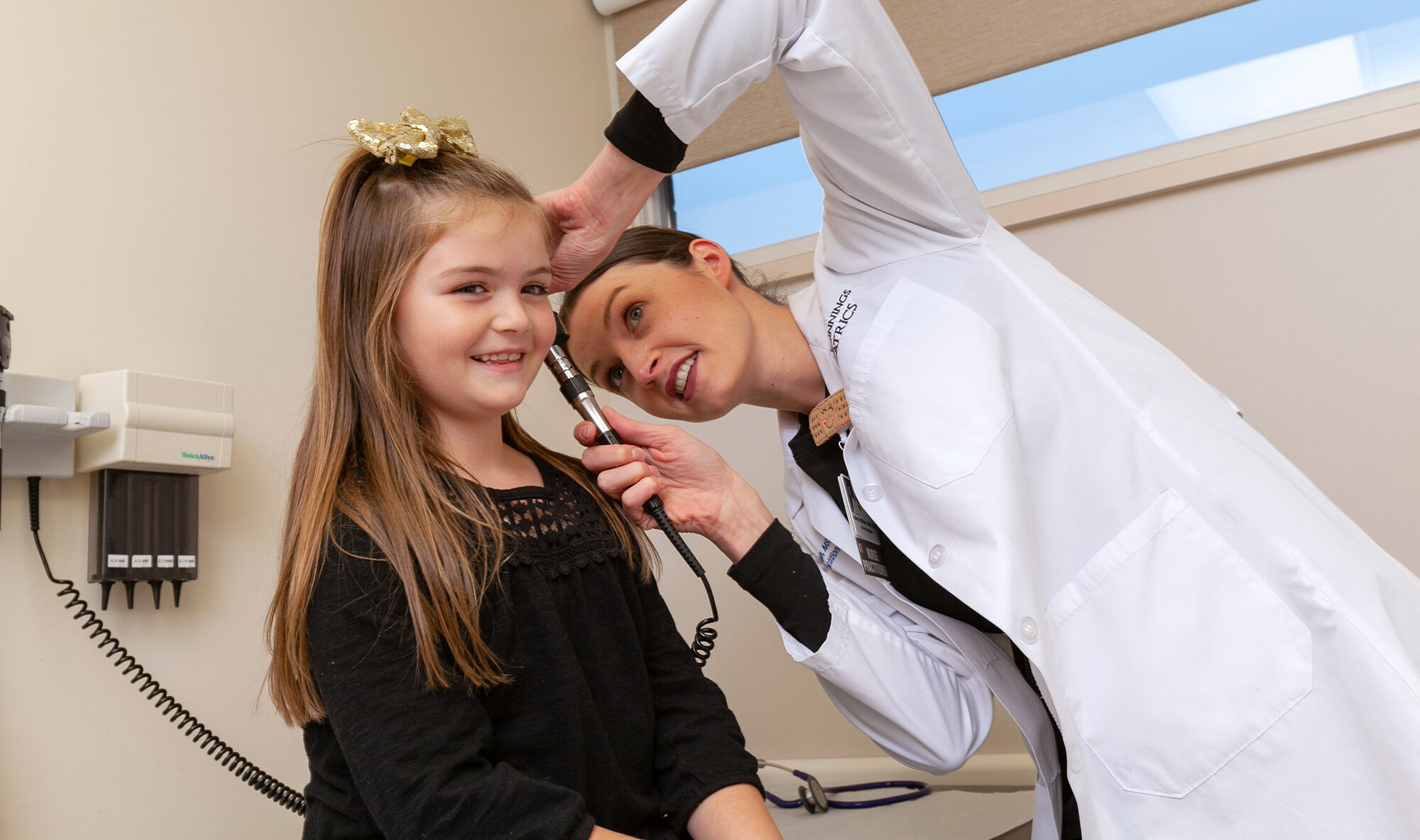 Provider checking the ears of a child patient.