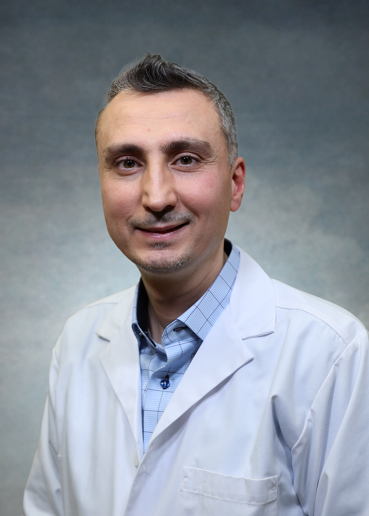 Mohamed Alalwani, MD, in a white coat.