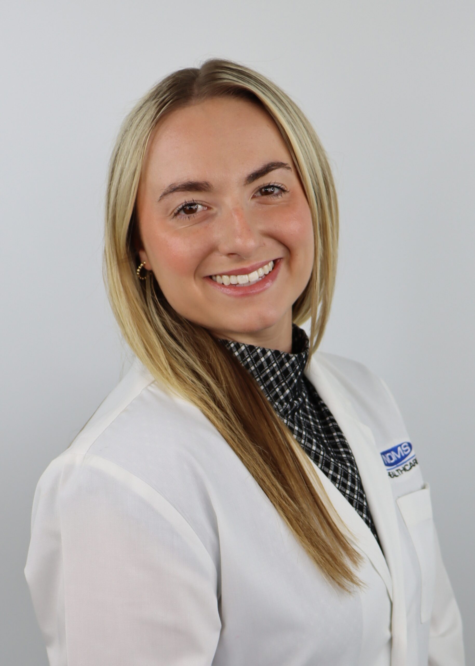 Regan Olak wearing a white coat.
